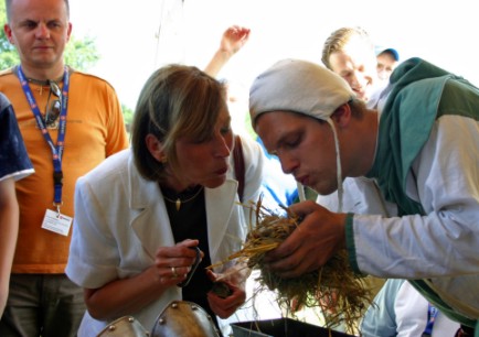 Frau Köhler lässt sich zeigen, wie früher Feuer gemacht wurde. Sie versucht es anschließend selbst